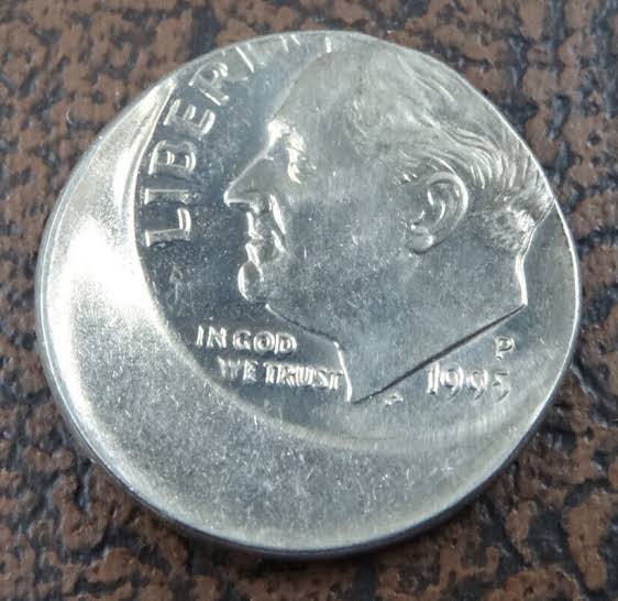 1995 Roosevelt dime off-center strike error showing misaligned design and blank planchet area